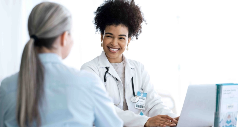 Médica a sorrir para uma paciente