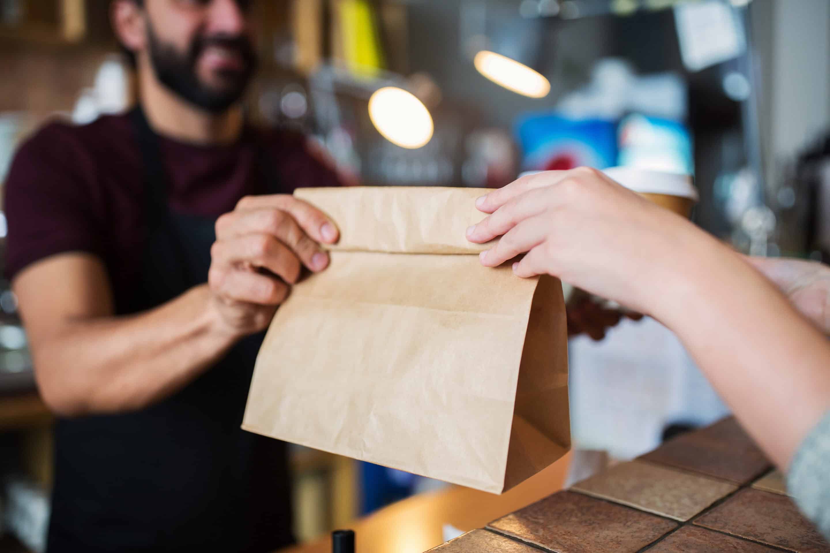persona trabaja en el takeaway de su cafeteria